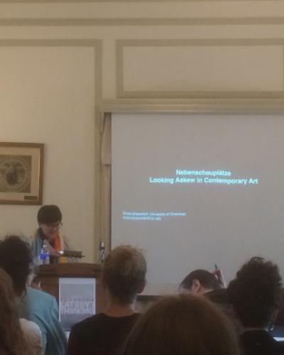 A student gives a conference presentation while standing behind a podium
